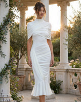 Enchant white twisted cape midi dress worn in a garden pavilion