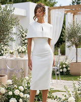 Baylor white cape midi dress worn in a wedding venue garden