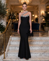 Isla black one-shoulder crystal-leaf mermaid maxi dress — hotel staircase